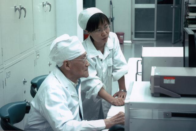 陆元九院士在航天时代电子公司激光陀螺实验室与同事探讨问题（2006年摄）。新华社发（中国航天科技集团供图）.jpg