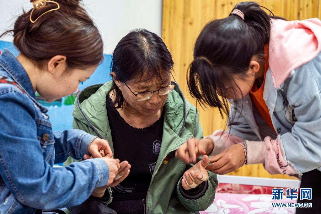 每天回到福利院，孩子们都会帮张桂梅撕掉贴了一天的止痛胶带（3月23日摄）。新华社记者 江文耀 摄.jpg